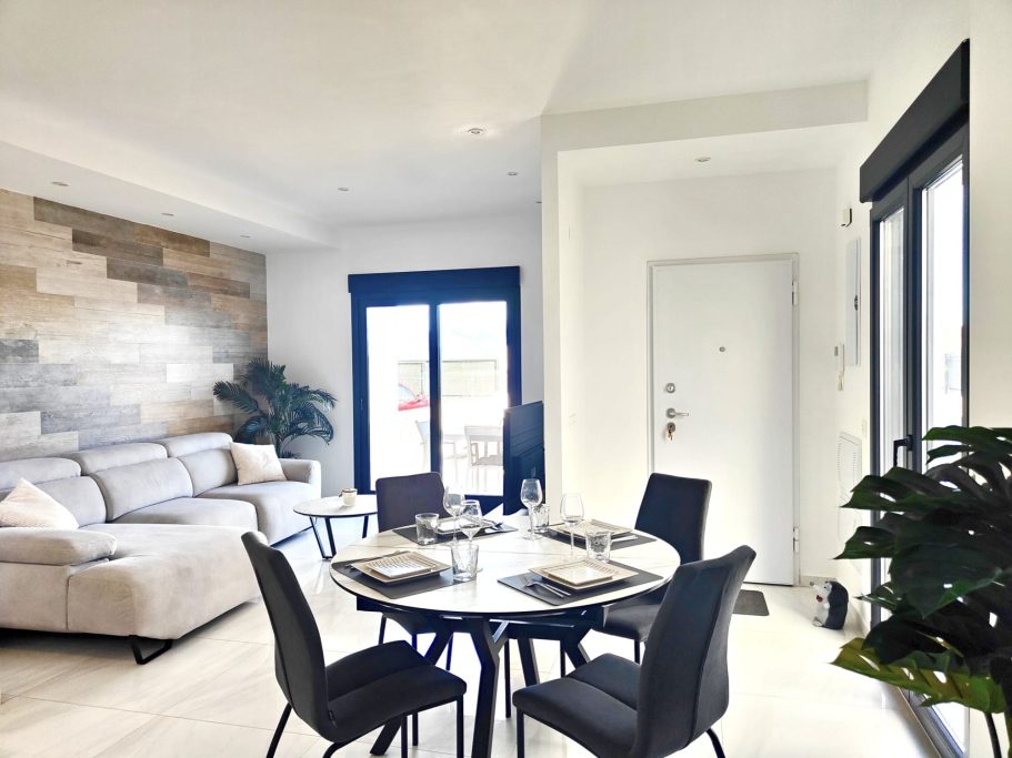 Grande pièce de vie traversante avec deux baies vitrées et espace repas au premier plan dans villa à Don Benito Altos de Polop