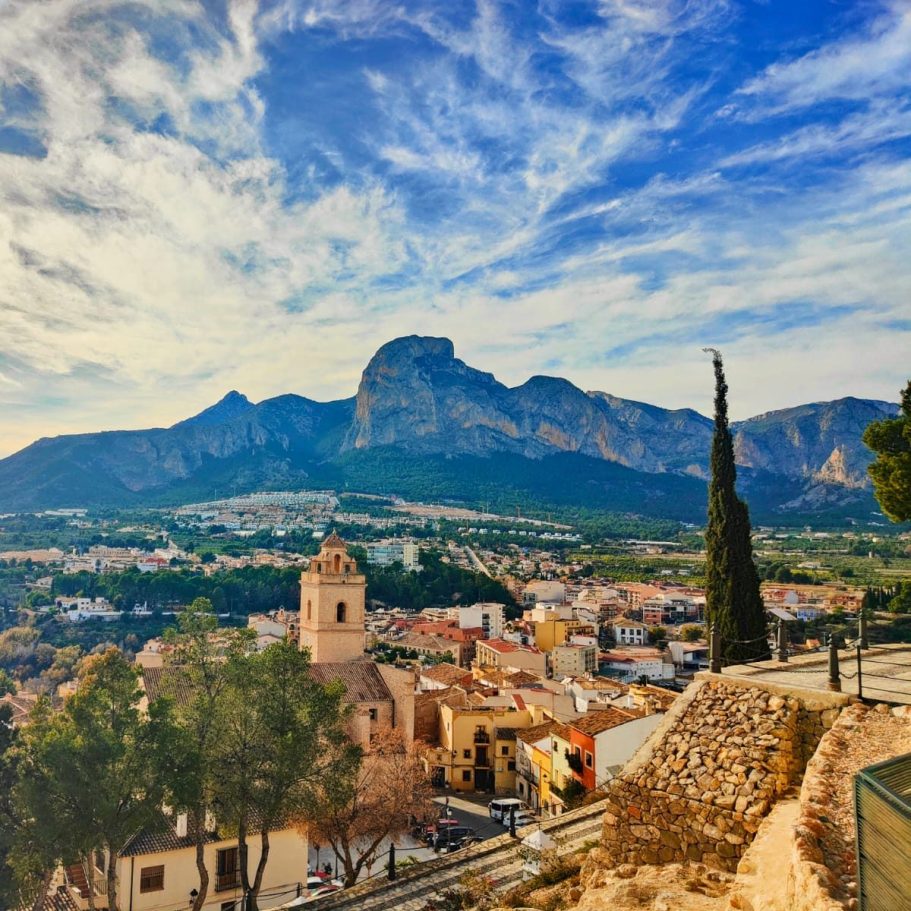 Photo panoramique des hauteurs de Polop, montrant l’église, le village et le Mont Poig, offrant un cadre authentique et paisible.