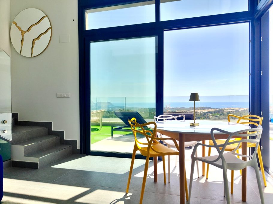 Espace repas avec chaises design donnant directement sur la terrasse et sa vue spectaculaire, Polop Hills.