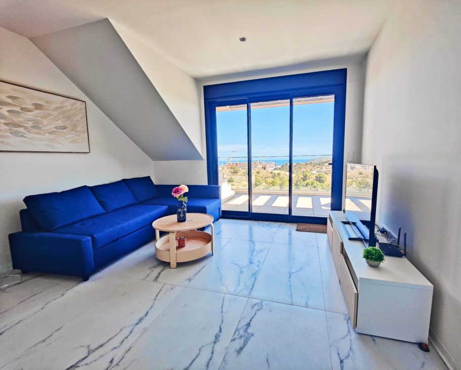 Salon moderne et lumineux ouvert sur la terrasse Salon moderne et lumineux avec baie vitrée donnant sur la terrasse au Balcon de Finestrat près de Benidorm