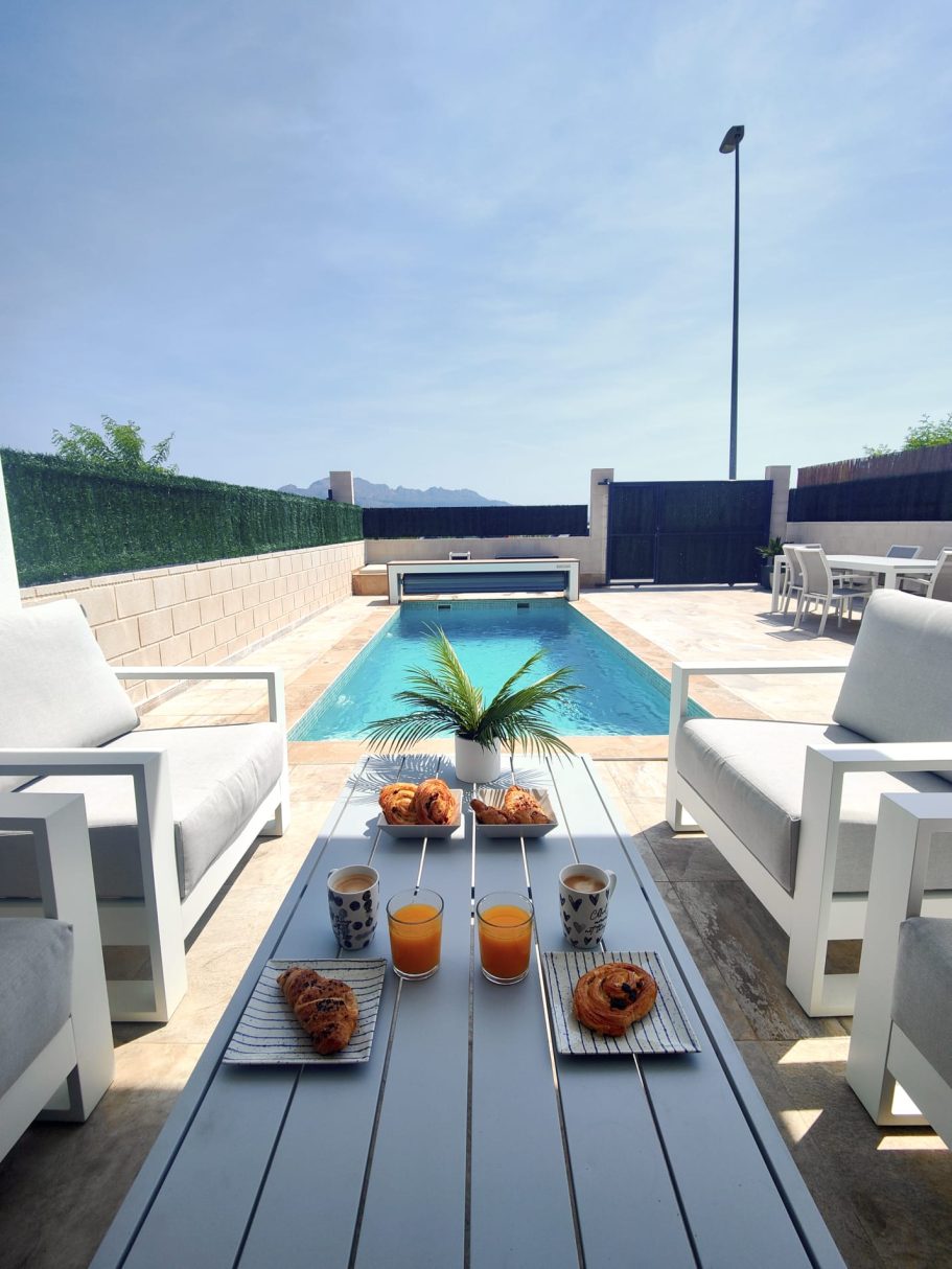 Petit déjeuner servi au bord de la piscine sur la terrasse d'une villa à Polop.