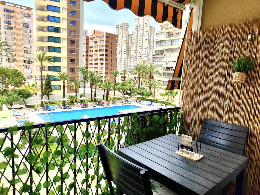 Balcon avec table et vue piscine à Benidorm Balcon du studio avec table pour deux personnes et vue sur la piscine de la résidence et les immeubles de Benidorm