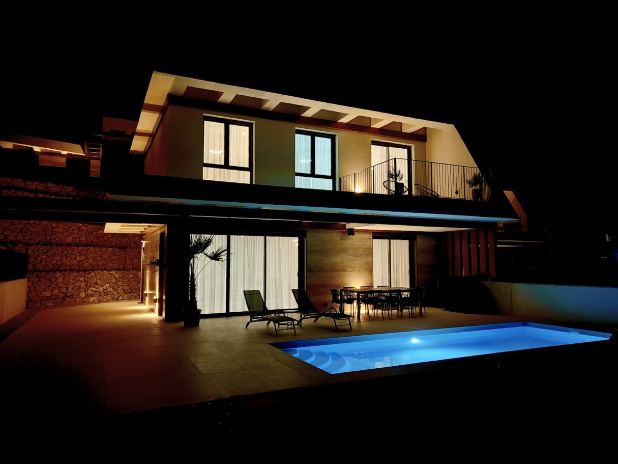 Façade de villa Polop Bay View de nuit avec piscine chauffée et lumières intérieures et extérieures – Costa Blanca