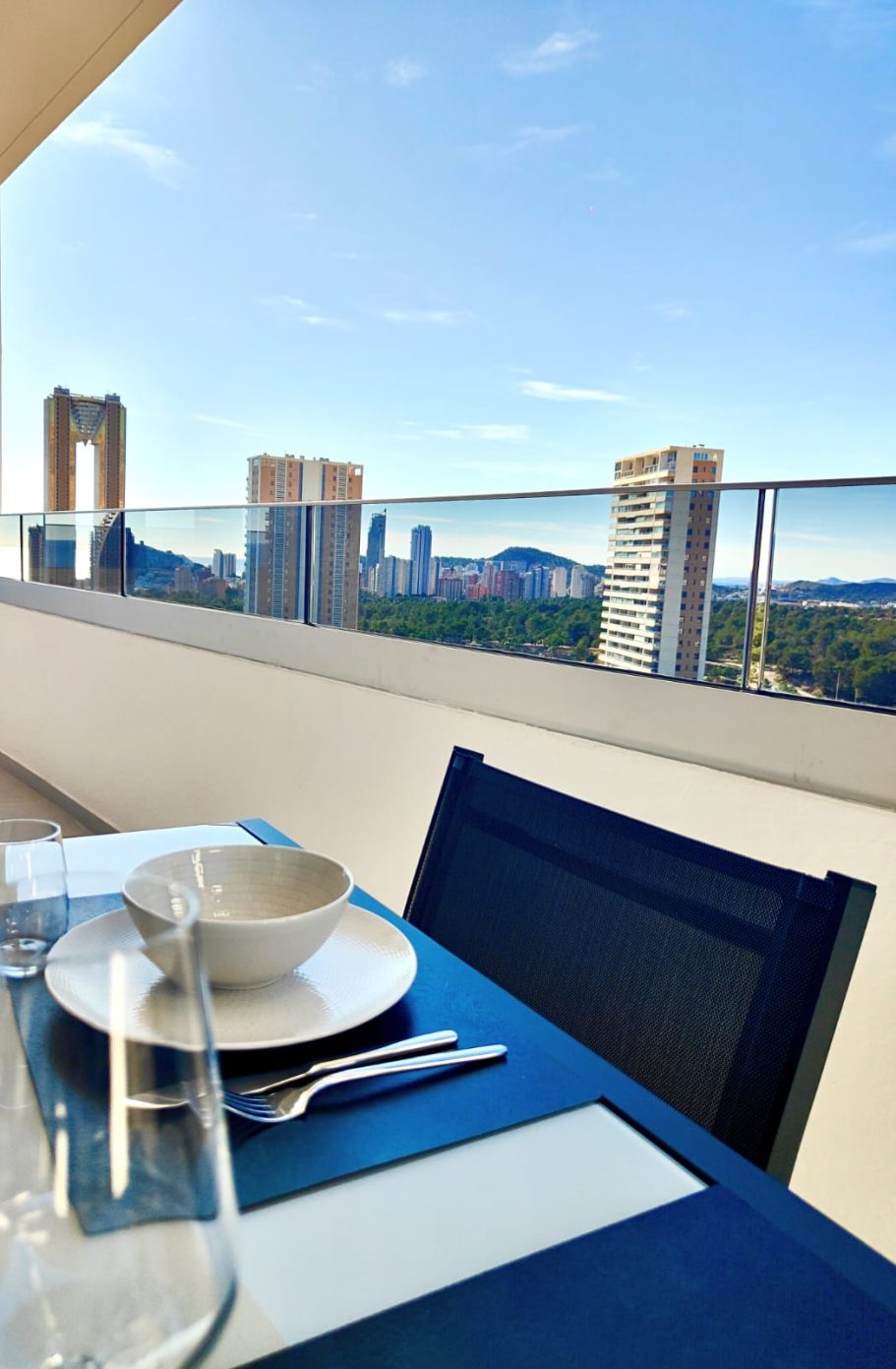 Appartement Eagle Tower Collection Signature – terrasse avec espace repas, verre à vin et vue sur la skyline de Poniente et la tour Intempo 