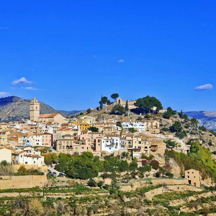 Photo panoramique des hauteurs de Polop, montrant l’église, le village et le Mont Poig, offrant un cadre authentique et paisible.