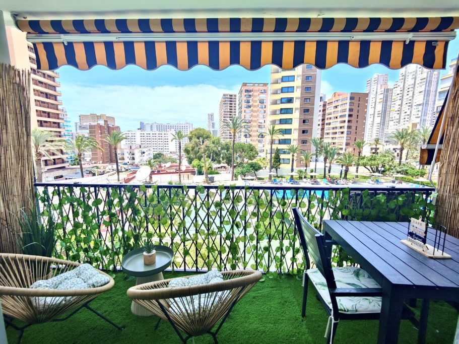 Balcon cosy du studio avec vue dégagée sur Benidorm Balcon du studio avec fauteuils et table, espace extérieur cosy avec pelouse artificielle et vue dégagée sur la piscine et Benidorm