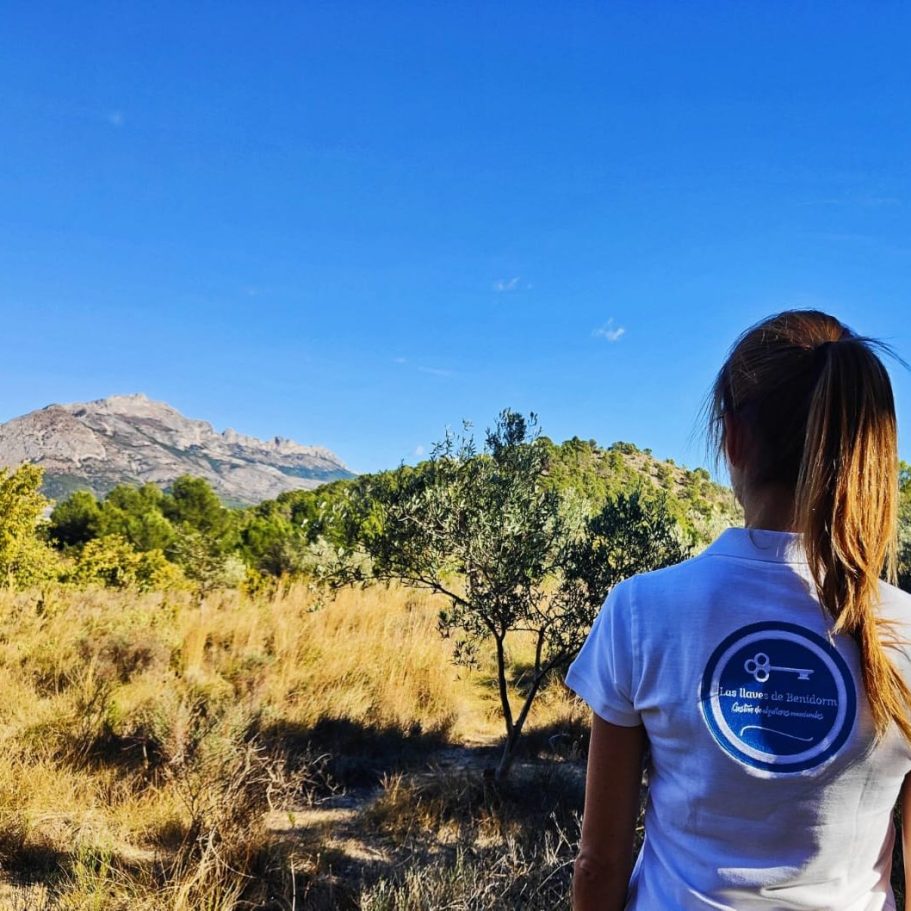 Photo de Sophie lors d’une balade sur un sentier à Chirles, près de Polop, entourée de nature et portant un polo Las Llaves de Benidorm.