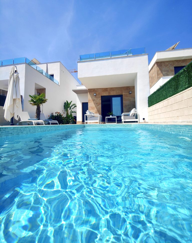 Piscine et terrasse Vue immersive au ras de la piscine avec salon de jardin, transats et terrasse d'une villa à Polop.