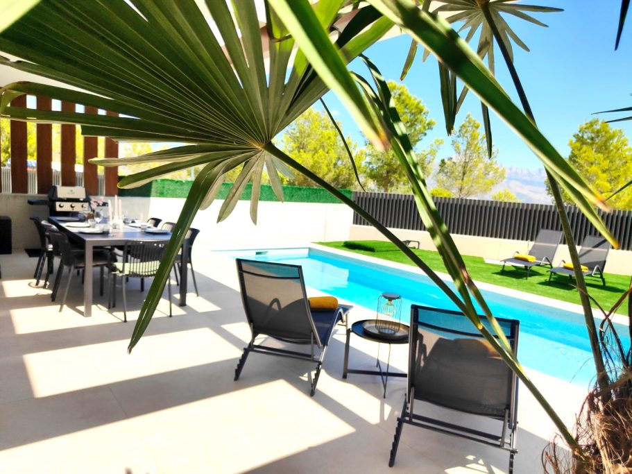 Terrasse de jour avec transats, piscine et espace repas – villa Polop Bay View