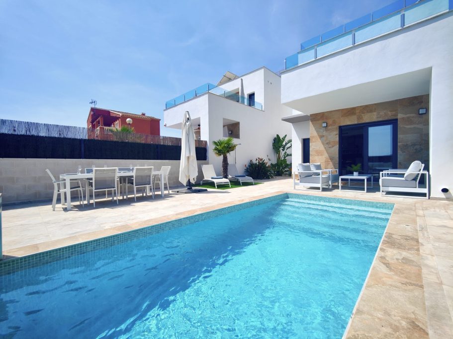 Terrasse de villa avec piscine, salon de jardin et espace repas extérieur.