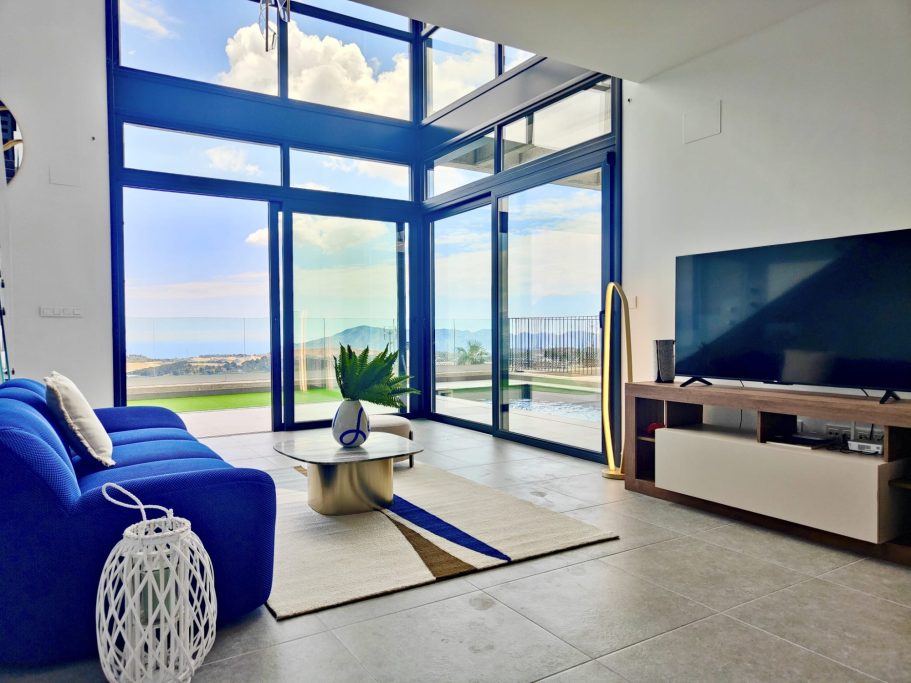 Salon ouvert sur terrasse – Polop Hills Salon lumineux avec canapé bleu ouvert sur terrasse – villa de luxe à Polop Hills